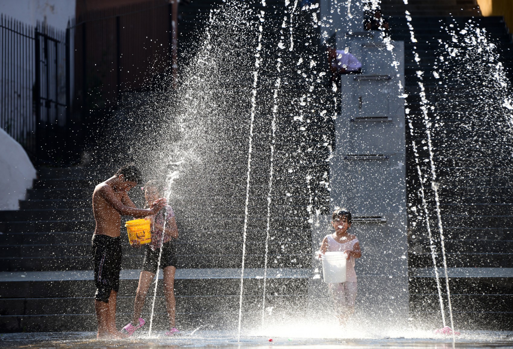 Niños juegan y se refrescan en las fuentes del barrio mágico de Xallitic