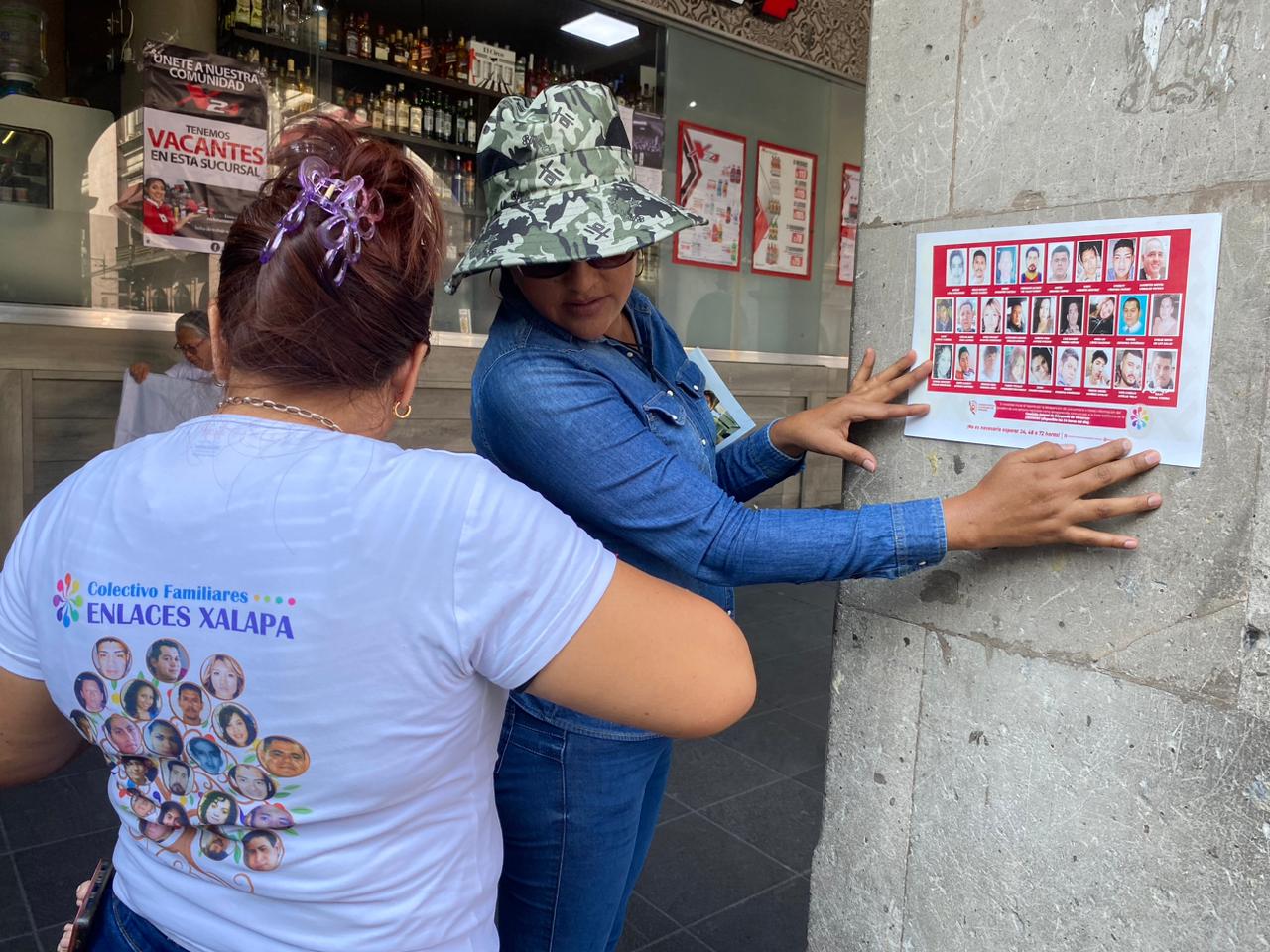 Colectivos de personas desaparecidas pegan fichas de búsqueda en el centro de Xalapa