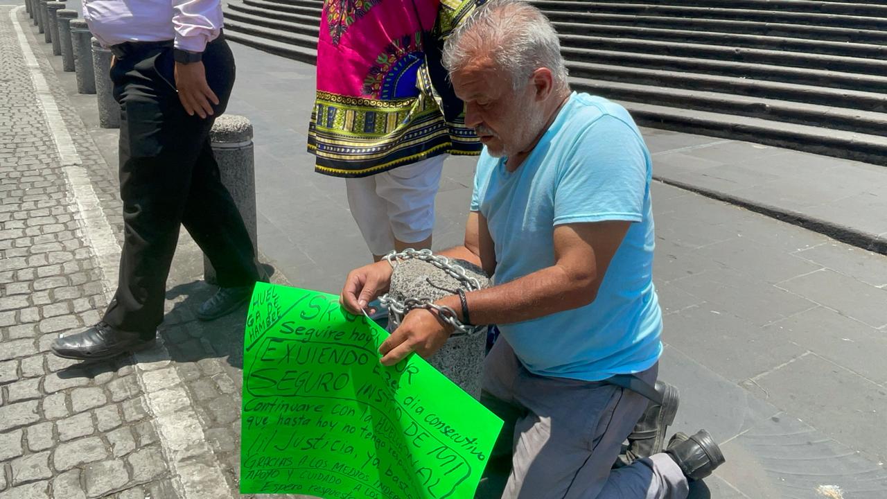 Maestro se encadena e inicia huelga de hambre para exigir pago de seguro institucional