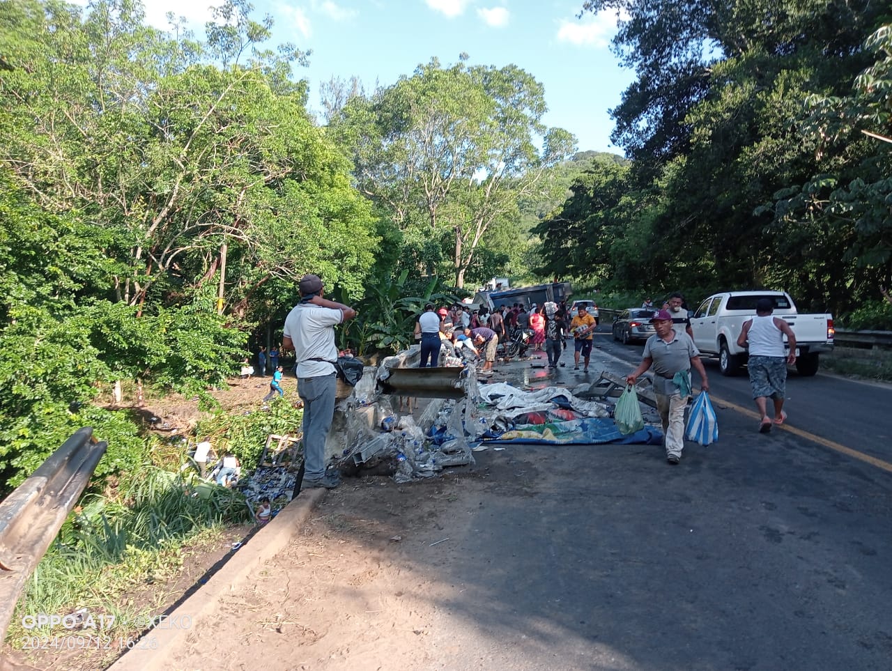 En San Andrés Tuxtla pobladores vacían carga de camión refresquero volcado en la Costera del Golfo