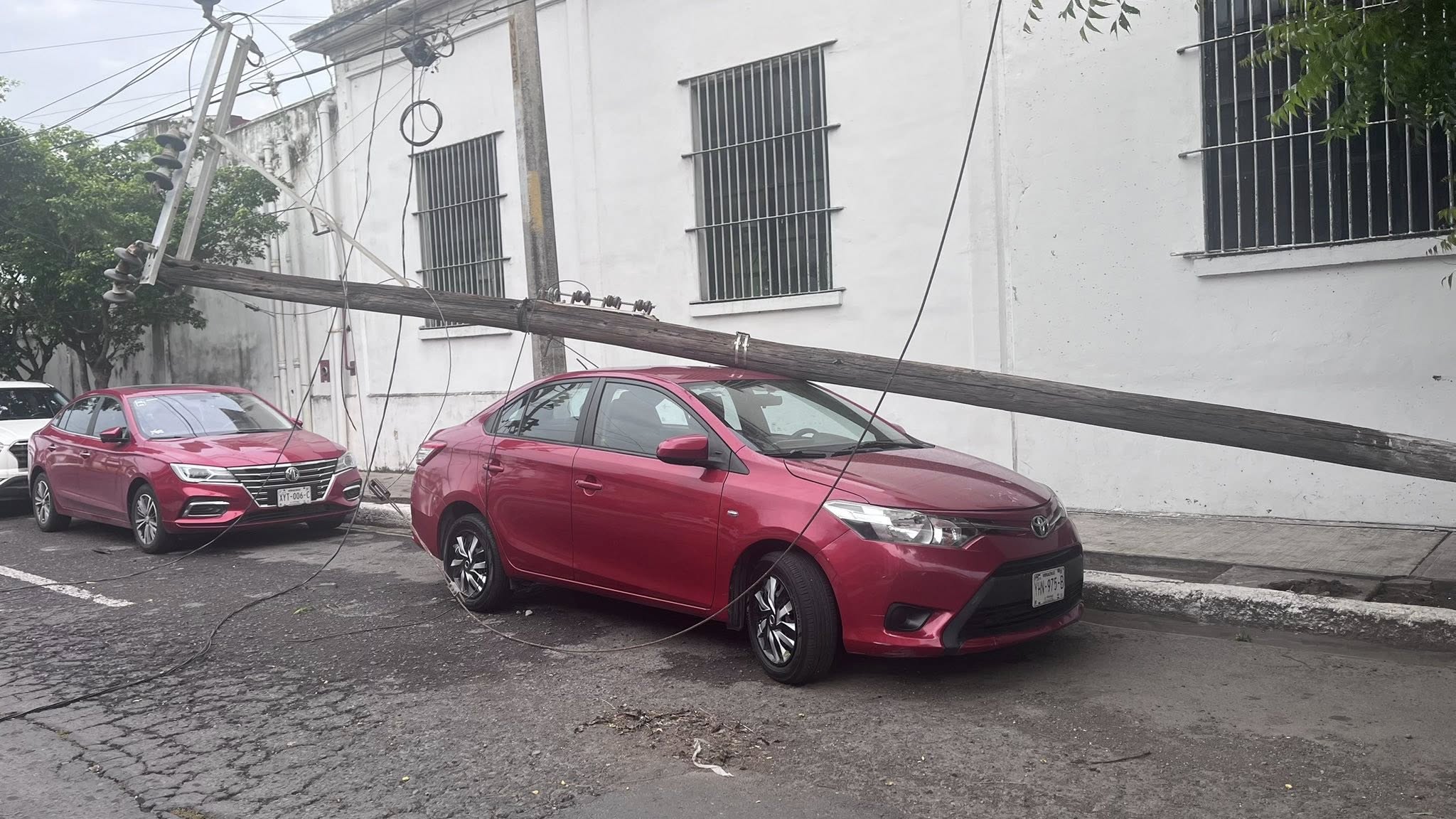 Poste de CFE cae sobre auto particular en el centro de Veracruz