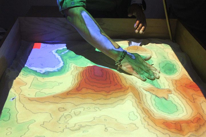 Académico y alumno construyen caja de arena para enseñanza de geografía